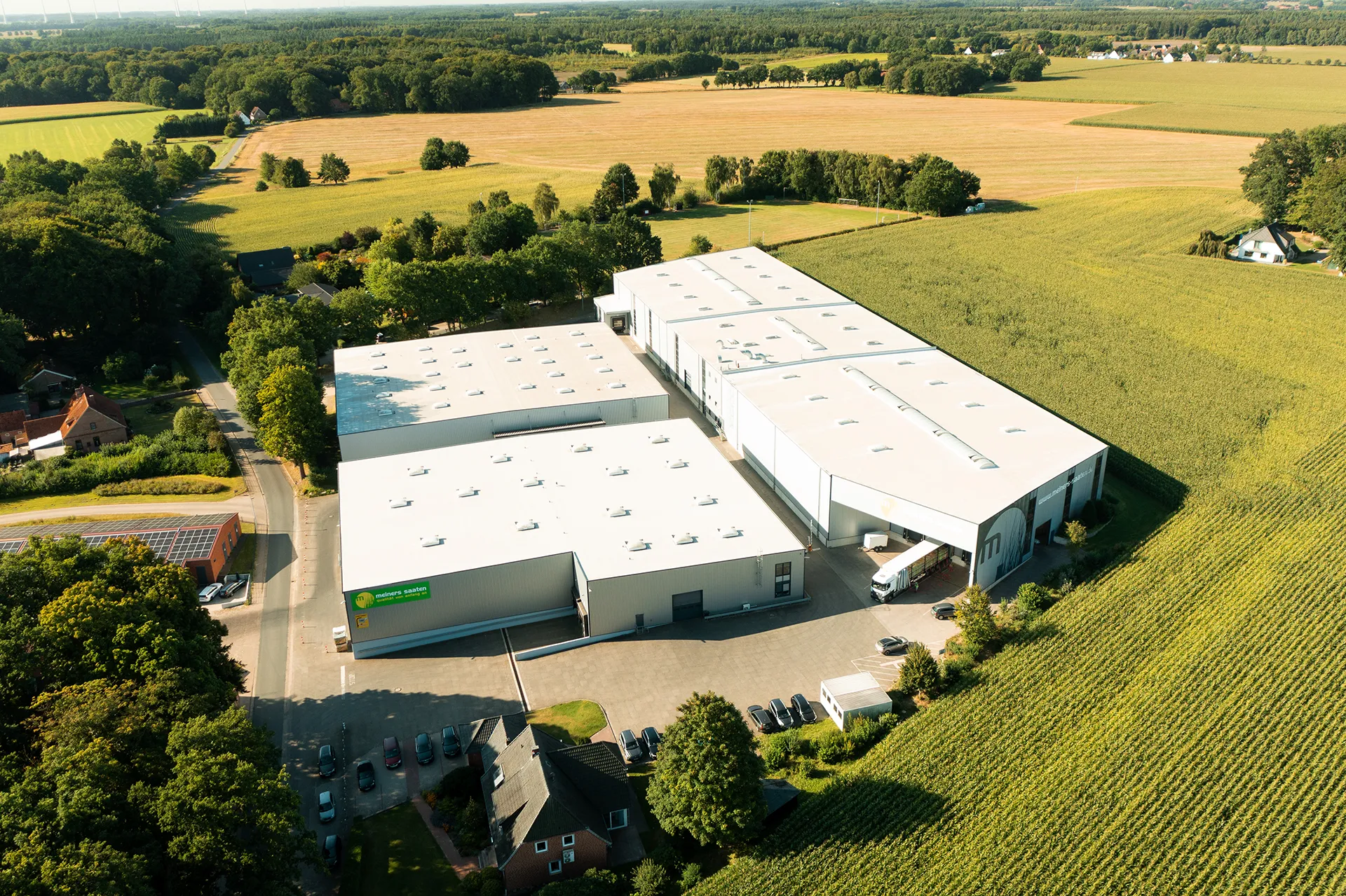 Luftaufnahme Meiners Saaten Firmengebäude, moderne Hallen, grüne Umgebung, nachhaltige Architektur, Standortaufnahme.