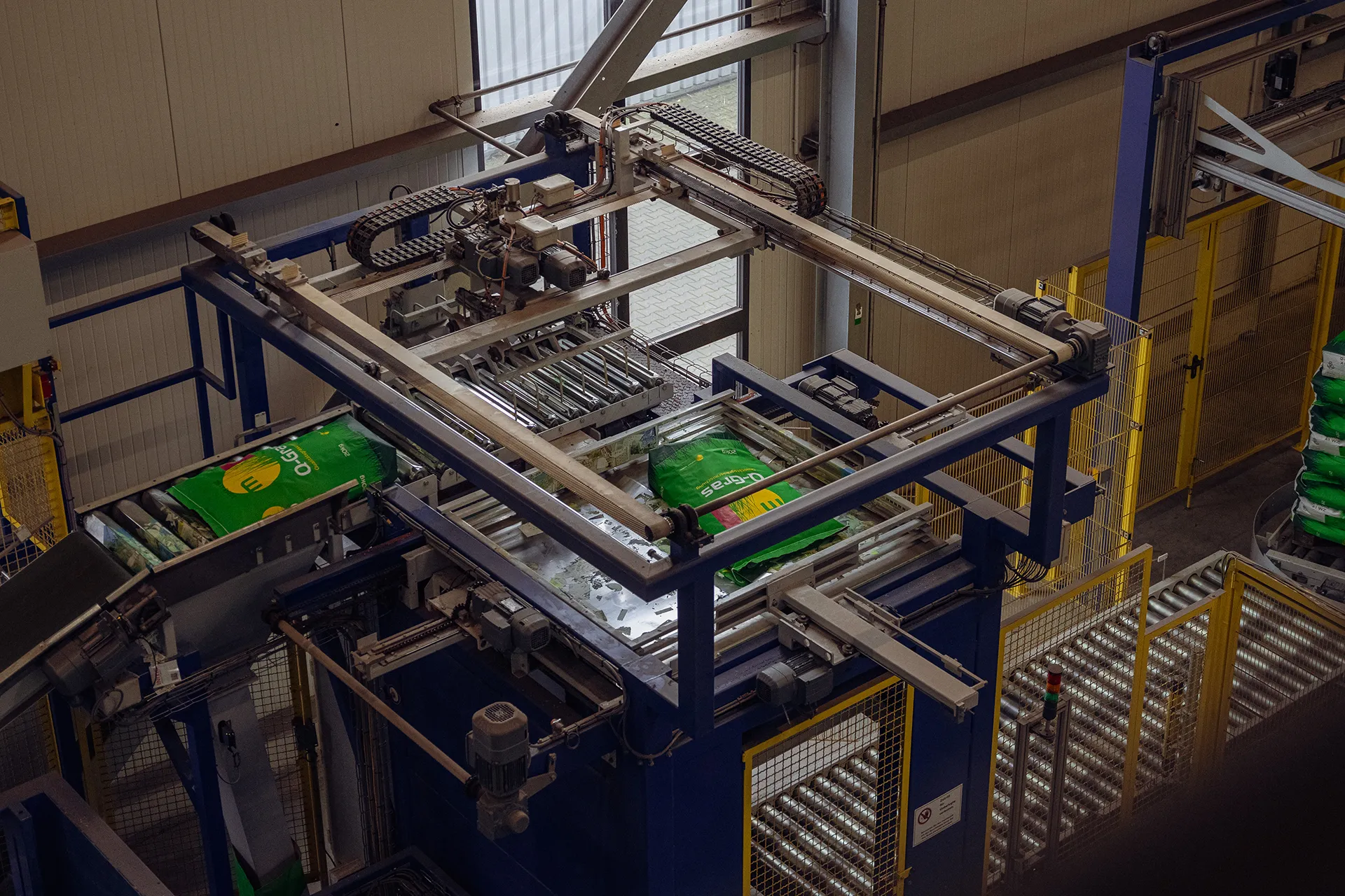 Palettierte Q-Gras Saatgutsäcke Meiners Saaten, versandbereit, automatisierte Fördertechnik, effiziente Logistikprozesse.